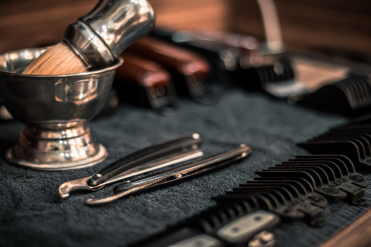 why-choose-us Close-up of neatly arranged barber tools, including razors and combs, highlighting precision.