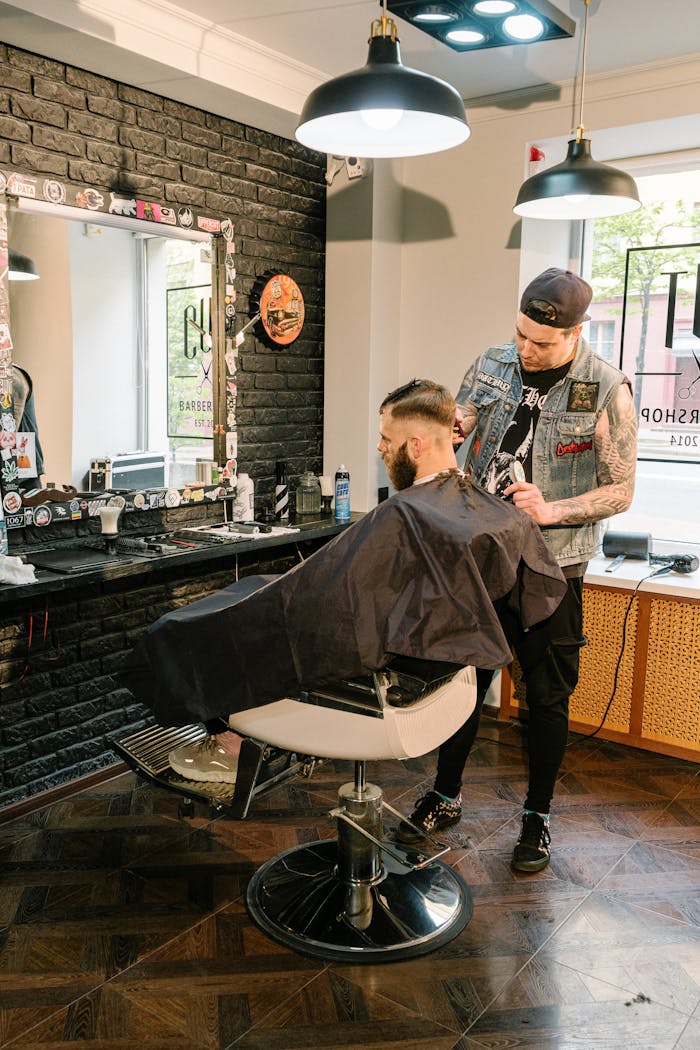 who-we-are A barber giving a stylish haircut to a client in a trendy urban barbershop.